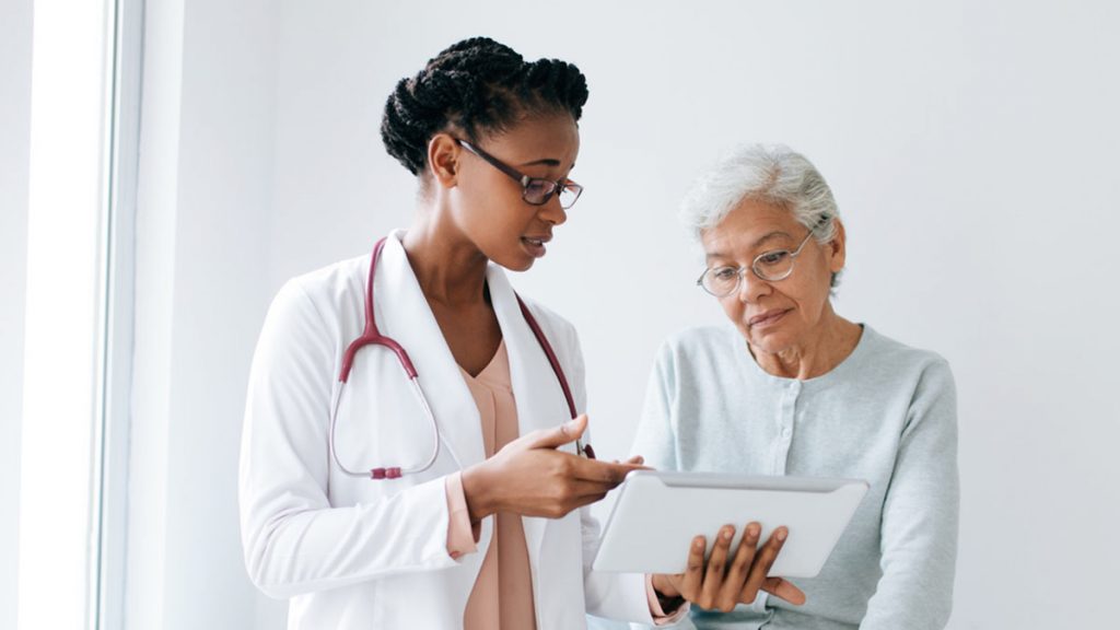 Doctor sharing her tablet screen to an elderly patient