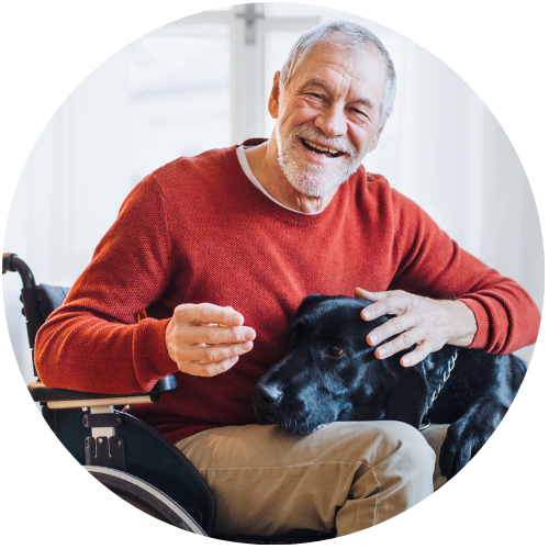 Person in wheelchair smiling with a dog
