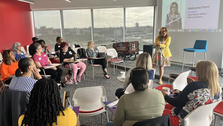 speaker addresses a room of seated workshop attendees