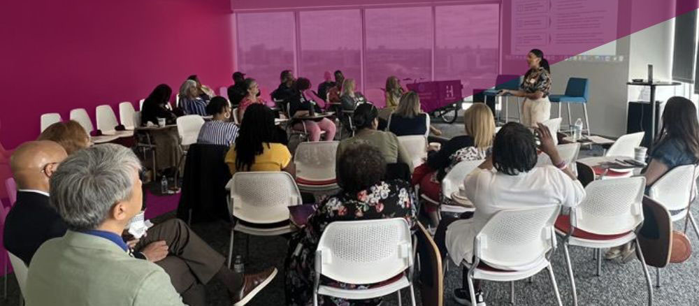 speaker addresses a room of seated people at a workshop