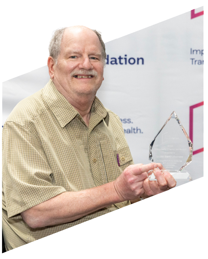 Scott holding his award, smiling