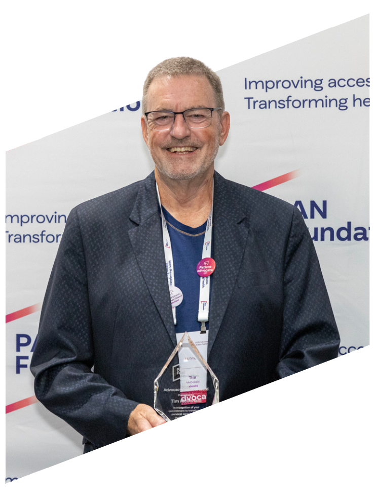 Tim holding his award, smiling