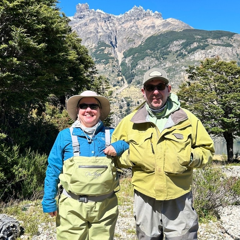 Denise and husband in outdoor gear in a wilderness area