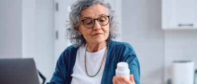 woman looking at prescription bottle